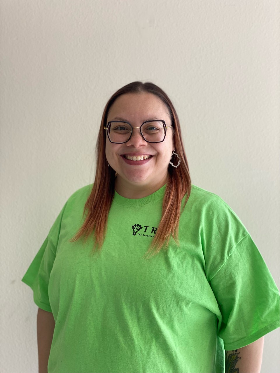 head shot of woman wearing green shirt smiling at the viewer