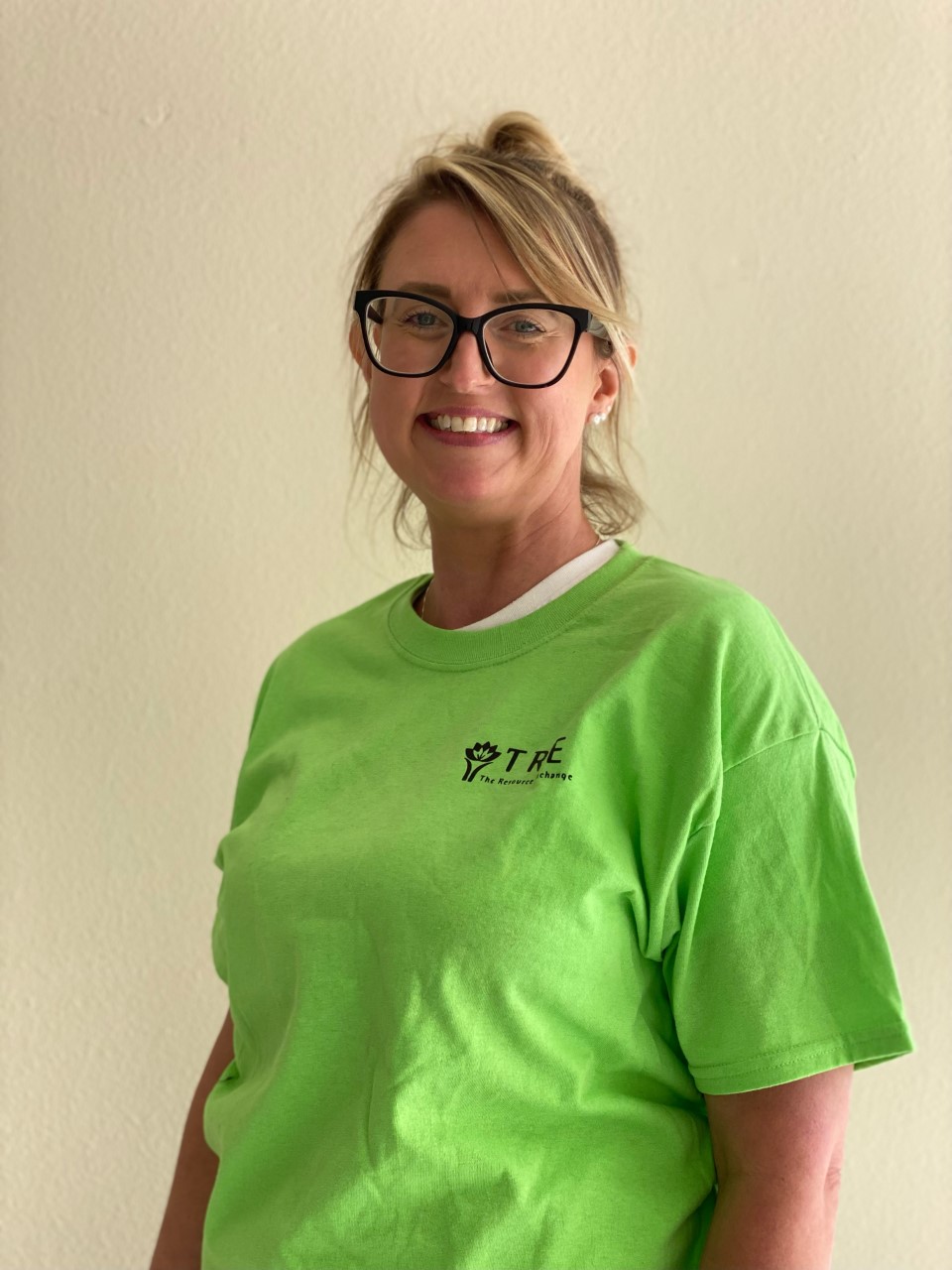 woman wearing green shirt smiling at the viewer