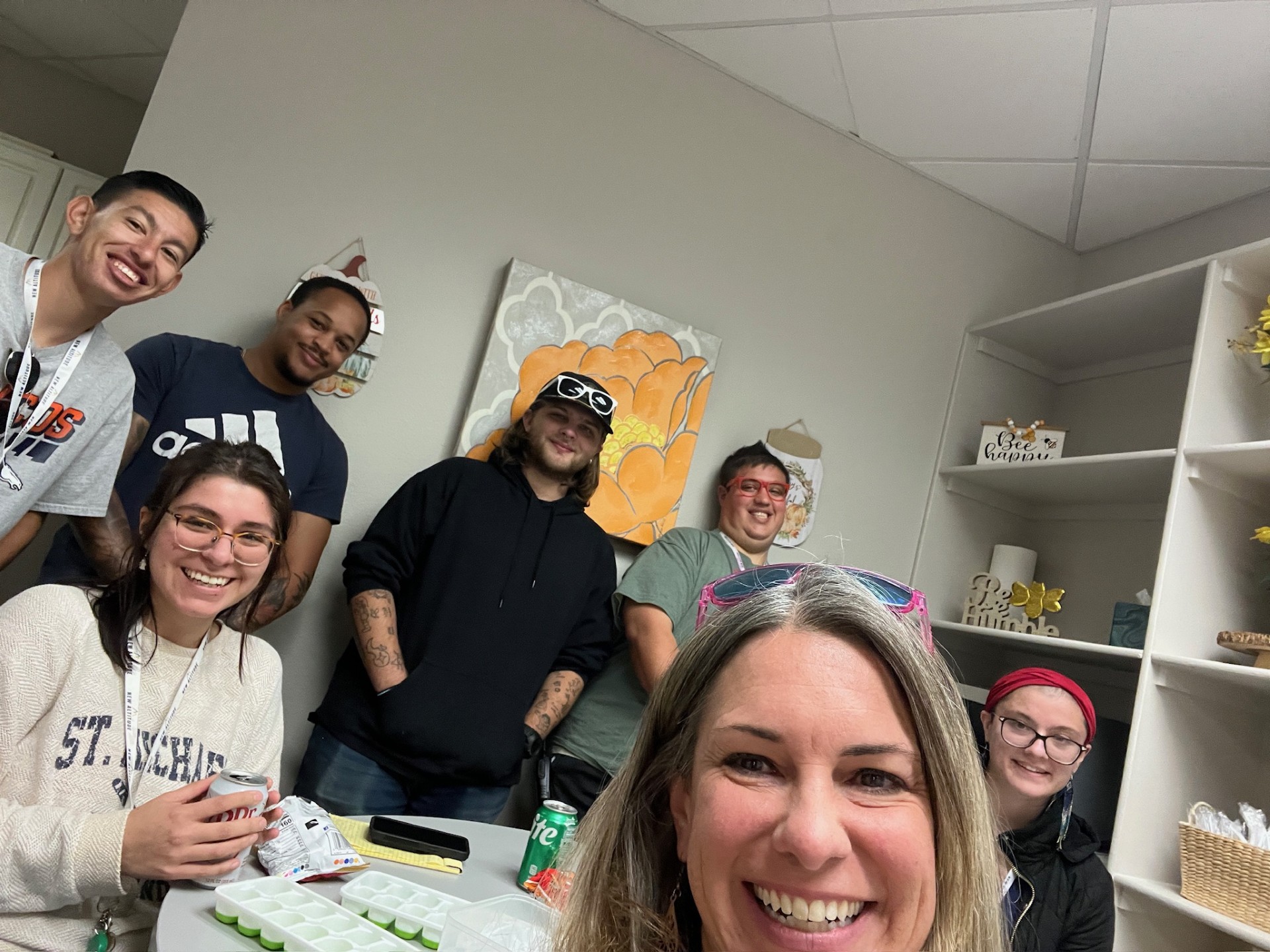 New Altitude team in the break room with Jenn and Katie sitting at a table with the interns standing behind them smiling